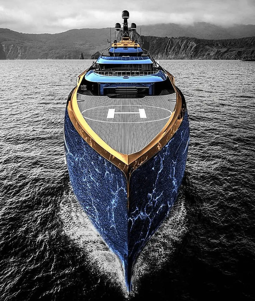 A luxury superyacht with a blue and gold hull and helipad, sailing on dark ocean water with mountains in the background.